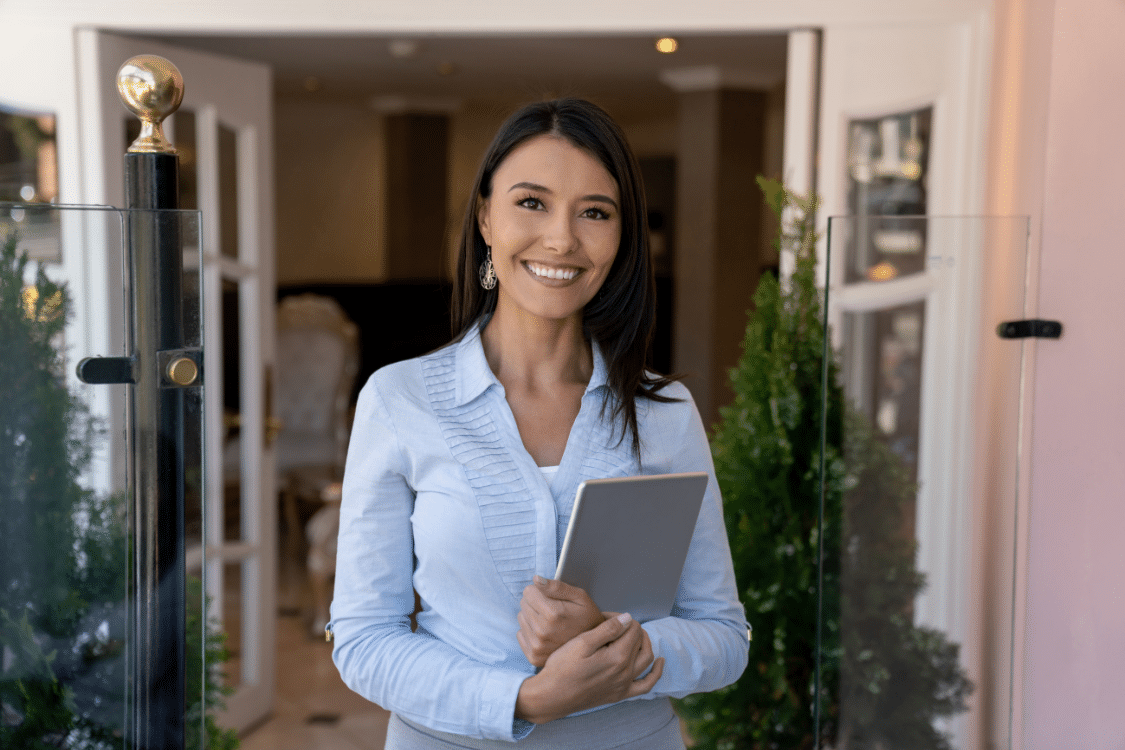 Household manager standing in front of home with clipboard