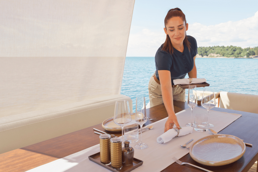 yacht-stewardess Yacht stewardess setting a table